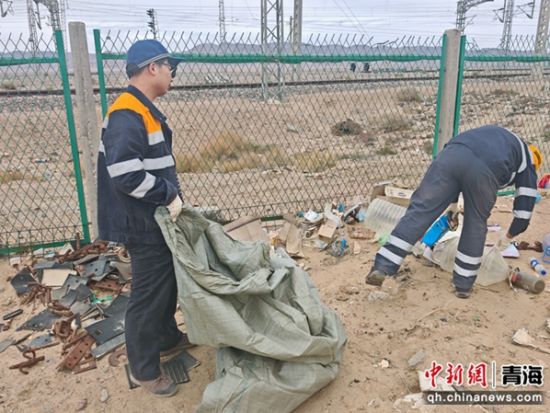 图为职工对铁路网围栏外生活垃圾进行清理。 罗维泰摄