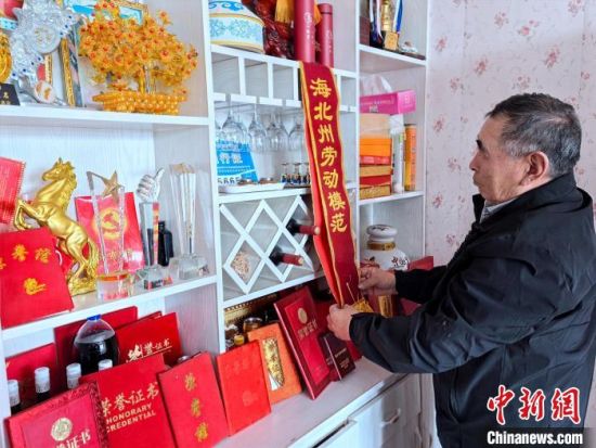 图为元才仔细整理获得的k8凯发官网的荣誉证书和绶带。李隽 摄