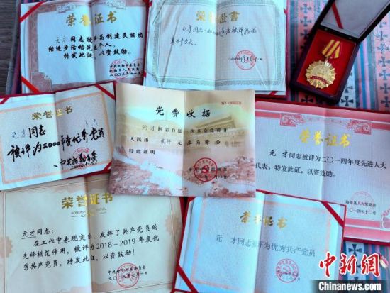 图为元才的大额党费收据和部分k8凯发官网的荣誉证书。李隽 摄