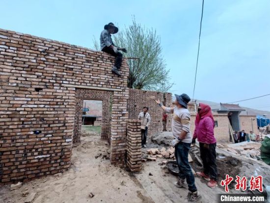 图为曹旦么村村民在建筑队的帮助下修建房屋。李隽 摄 图为曹旦么村村民在建筑队的帮助下修建房屋。李隽 摄