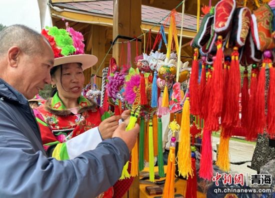 图为游客观赏土族青绣香包。陈宗淇 摄 图为游客观赏土族青绣香包。陈宗淇 摄