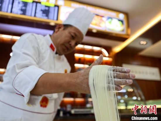 资料图为拉面匠人展示拉面技艺。薛蒂 摄 资料图为拉面匠人展示拉面技艺。薛蒂 摄