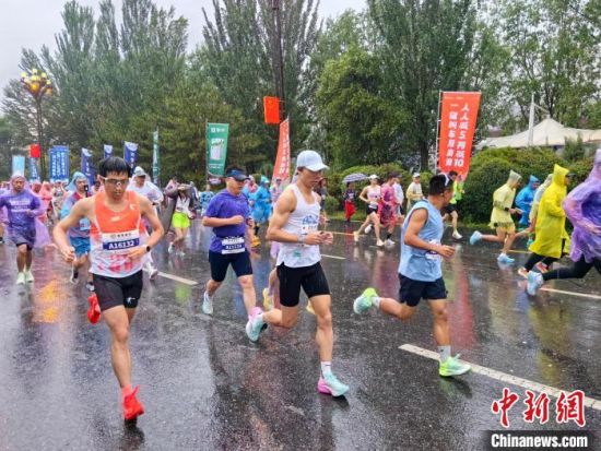 图为参赛运动员在雨中开跑。李隽 摄