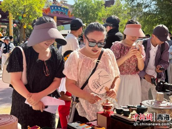 图为民众欣赏银铜器制作及鎏金技艺。祁绣娟 摄