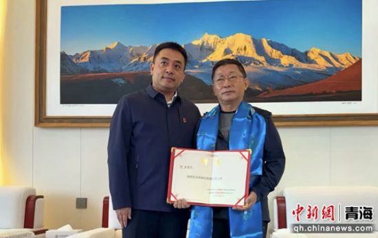 图为中共果洛州委常委、统战部部长祁乐廷(左)为阿来颁发聘书。仁增桑俄摄 图为中共果洛州委常委、统战部部长祁乐廷(左)为阿来颁发聘书。仁增桑俄摄