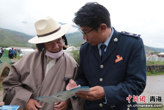 图为税务干部为赛马会上的观众讲解城乡居民“两险”相关政策 。闹文求占摄 图为税务干部为赛马会上的观众讲解城乡居民“两险”相关政策 。闹文求占摄