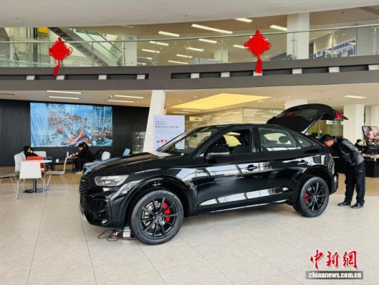 图为市民在汽车销售店购买汽车，享受以旧换新政策。孙睿 摄