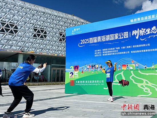 图为跑者在主题墙前留影。刚察县委宣传部供图