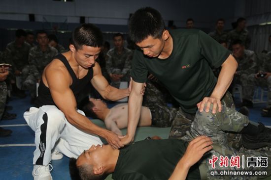 图为余乐斌教练团队成员正在向战友们教授腿部筋膜及肌肉放松方法。 刘进峰摄