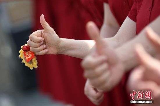 资料图：2024年高考，送考老师为考生加油鼓劲。 中新社记者 泱波 摄