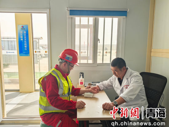 图为医生给项目施工人员把脉问诊。 水电四局供图