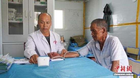 图为安置点内医护人员为村民测量血压。　祁妙摄