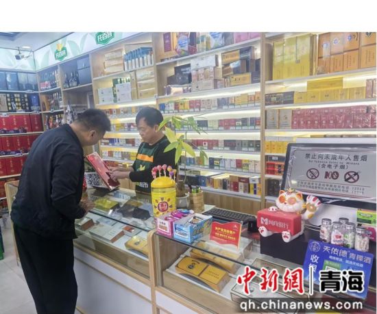 图为海北州海晏县局加盟零售终端店店主向消费者介绍卷烟鉴别知识。连东锋 摄