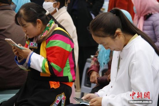 图为活动现场，民众代表在手机上做知识竞答。陈宗淇 摄