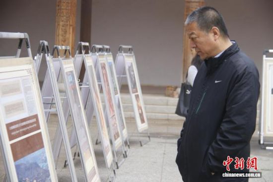 图为活动现场，民众观看活动宣传展板。陈宗淇 摄