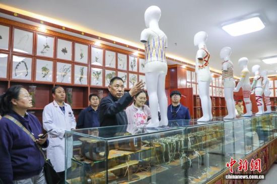 图为果洛州藏医院党委书记(左三)介绍藏医药体外治疗技术。马铭言 摄