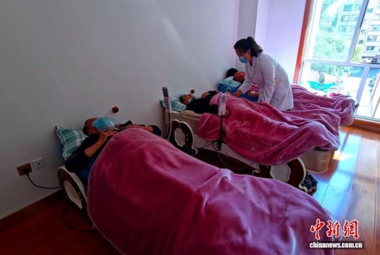 资料图为社区工作人员为辖区老人提供康复服务。李隽 摄 资料图为社区工作人员为辖区老人提供康复服务。李隽 摄