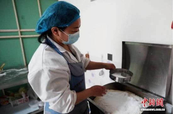 图为农户利用机器和面。严静怡 摄