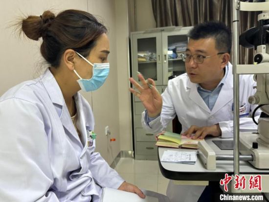 资料图为颜繁诚(右)与玉树州人民医院眼科中心医生交流。潘雨洁 摄 资料图为颜繁诚(右)与玉树州人民医院眼科中心医生交流。潘雨洁 摄