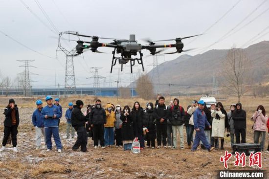 图为大学生观看电力检修工作人员展示的运载无人机。薛蒂 摄 图为大学生观看电力检修工作人员展示的运载无人机。薛蒂 摄